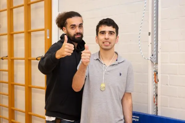 Begeleider en cliënt staan in de sportzaal