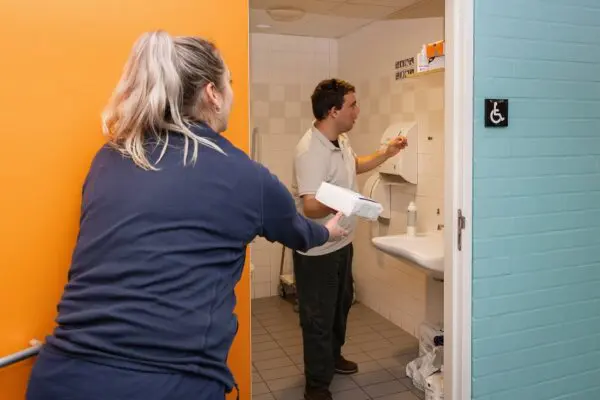 Begeleider helpt client bij het zelfstandig uitvoeren van een taak