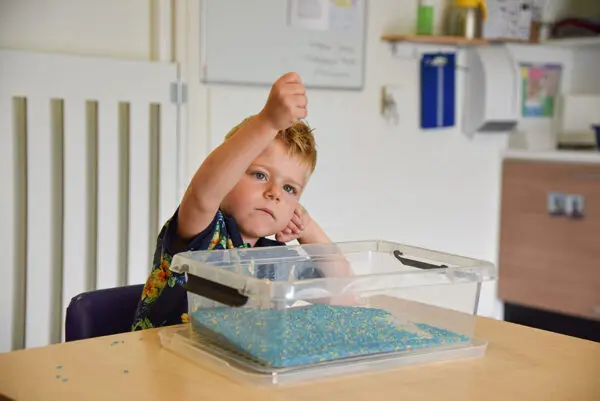 jongetje speelt met kraaltjes op Duinhuis