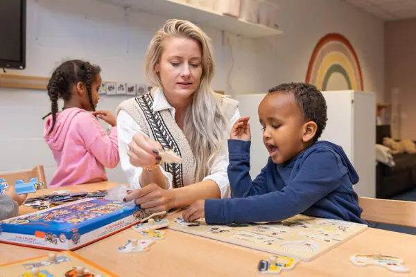 Begeleider en kind puzzelen op IKC IJmond