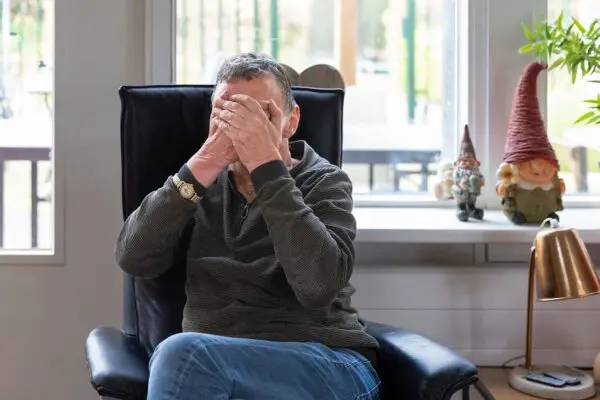 Cliënt slaat handen voor gezicht