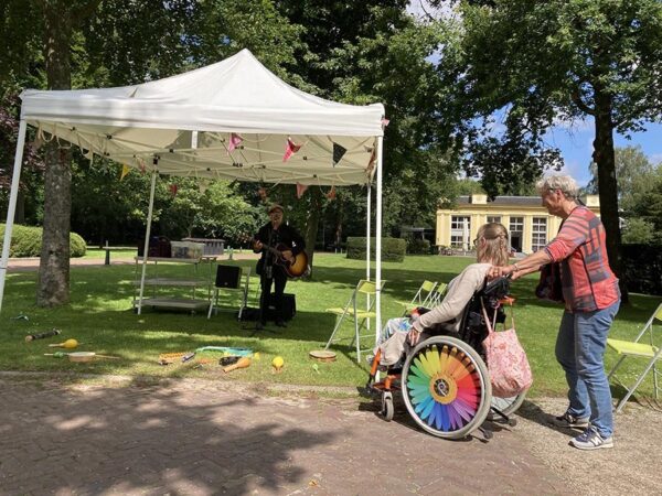 Vrijwilliger duwt rolstoel op de Hartekamp